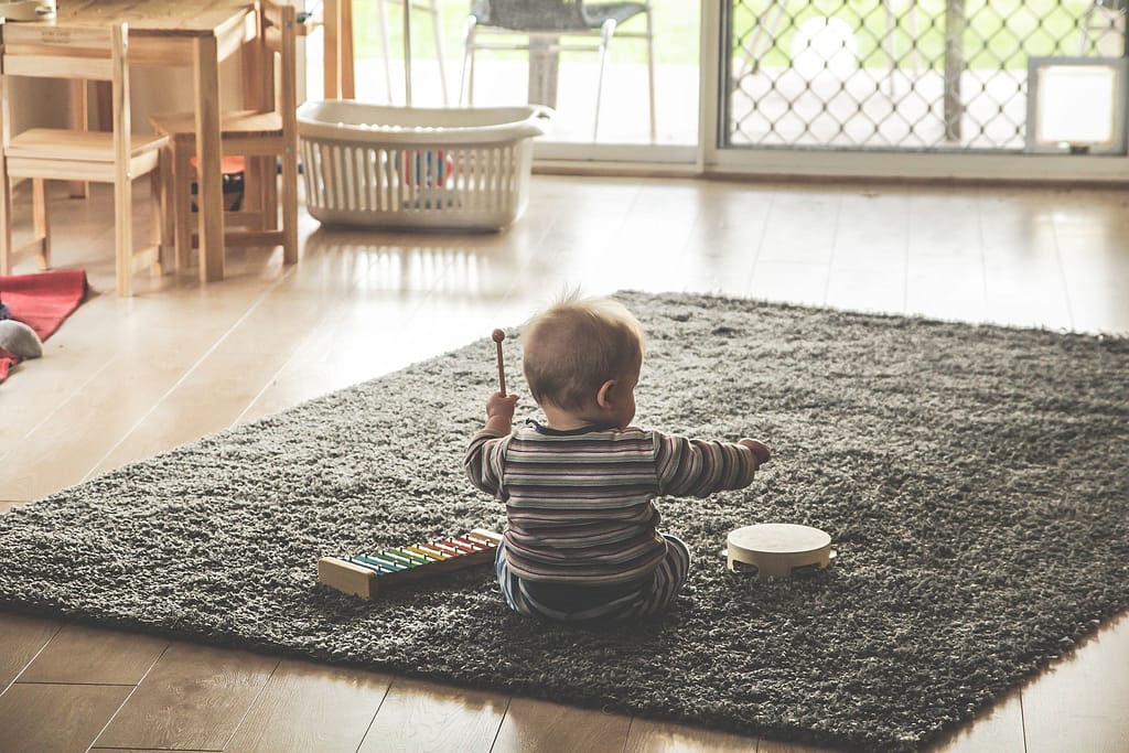 baby playing music on floor