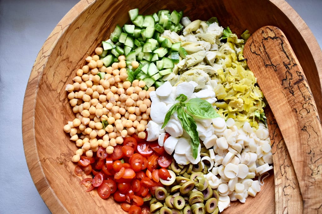Italian chopped salad in large serving bowl with tongs
