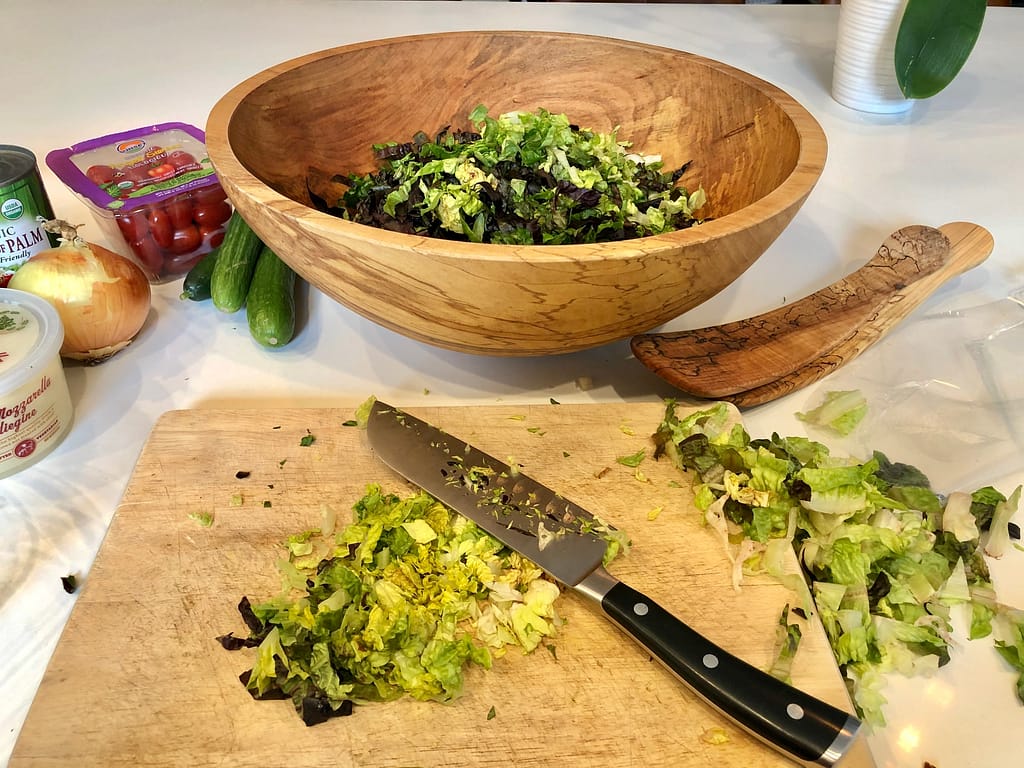 Chopping little gem lettuce for Italian chopped salad