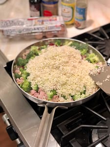 Making cauliflower fried rice: frozen cauliflower rice, carrots and broccoli added to sauteed onion, garlic, turkey and egg.