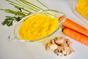 Blended carrot, ginger, rice vinegar, sesame oil, rice vinegar avocado oil in blender for beautifully balanced carrot ginger dressing and macro plate sauce.