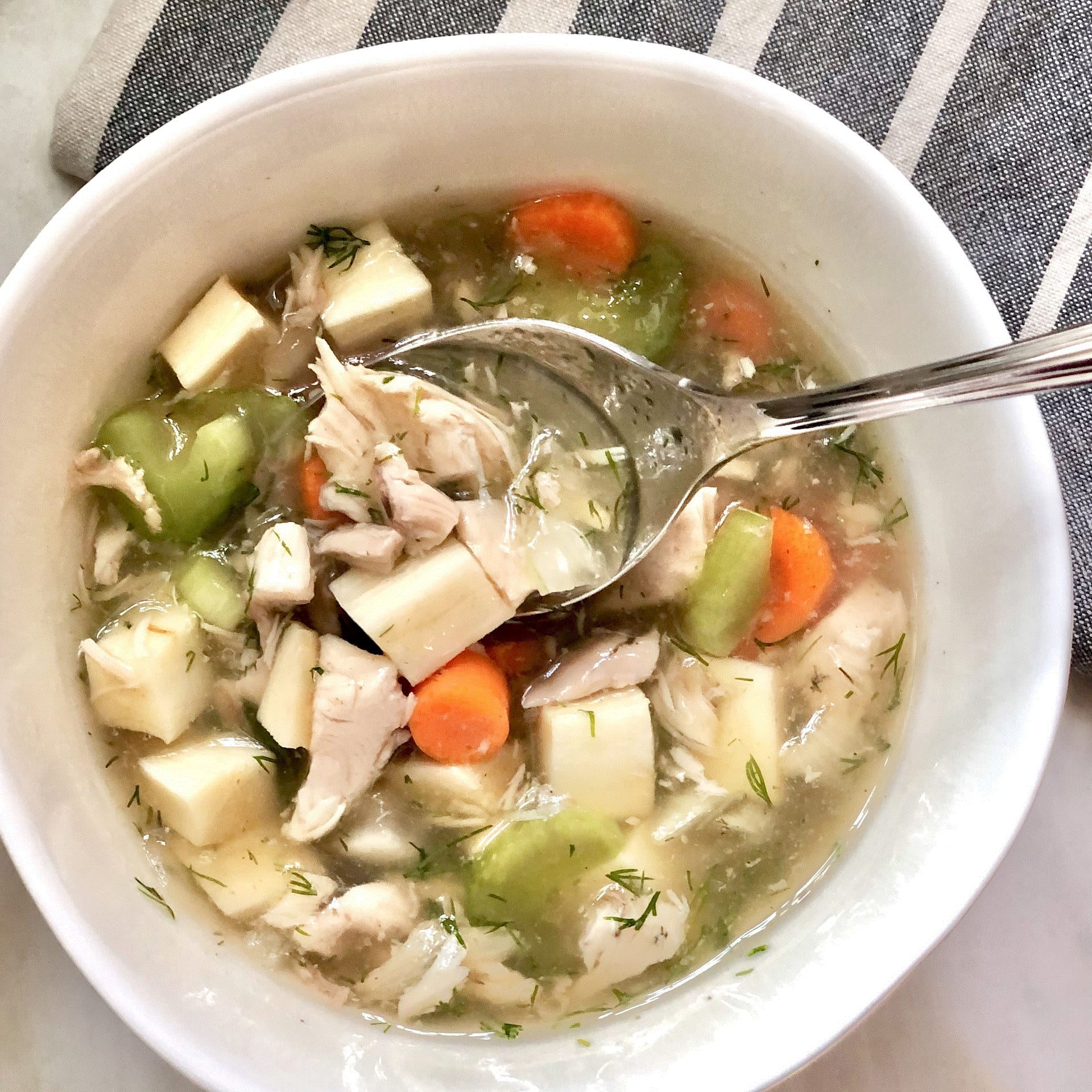 Bowl of Instant Pot chicken soup with vegetables and spoon