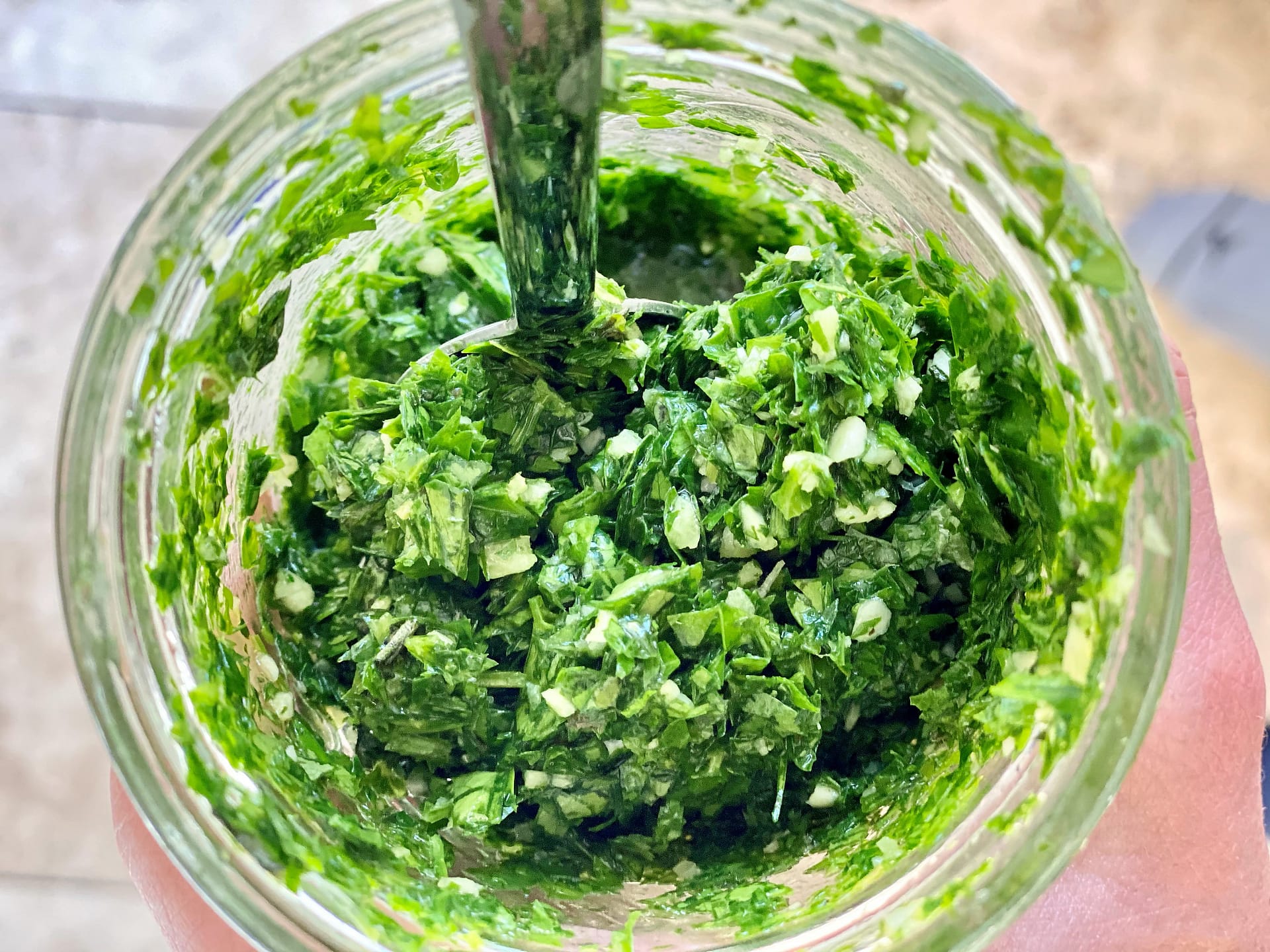Close up of chimichurri sauce in glass jar