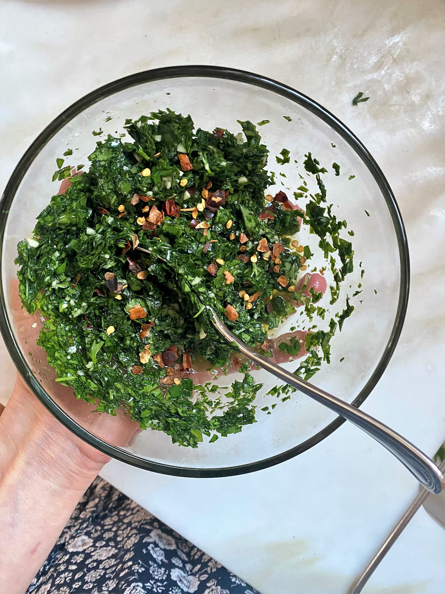 Chopped parsley, cilantro, olive oil, garlic and chili flakes for chimichurri recipe