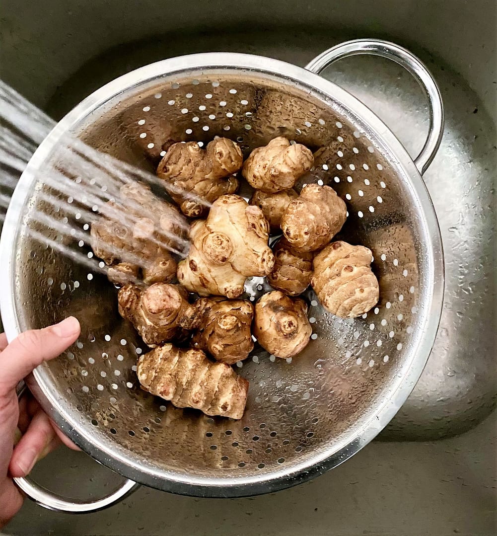 Rinsing sunchokes in colander