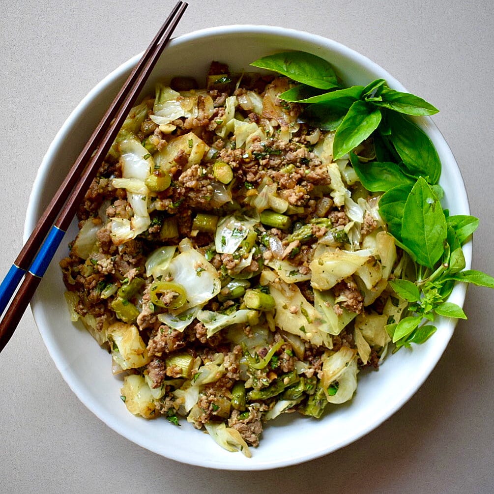 Pork stir fry with asparagus, cabbage, garlic, ginger, jalapeno and basil