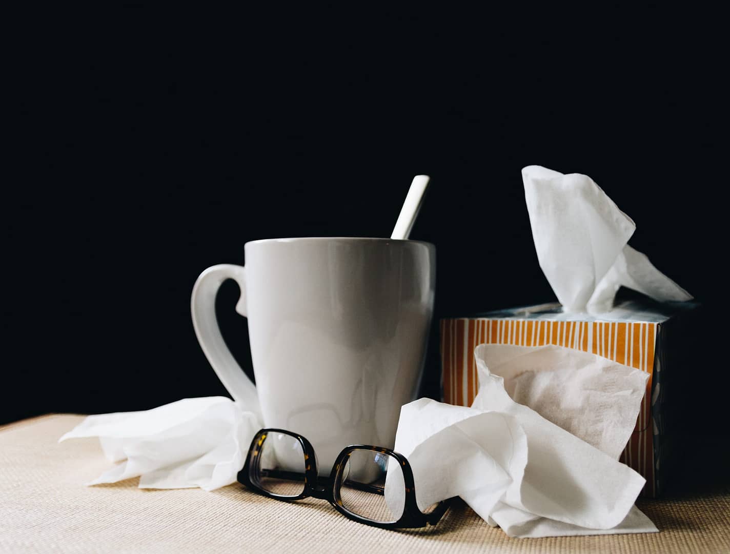 tea, used tissues and classes on table