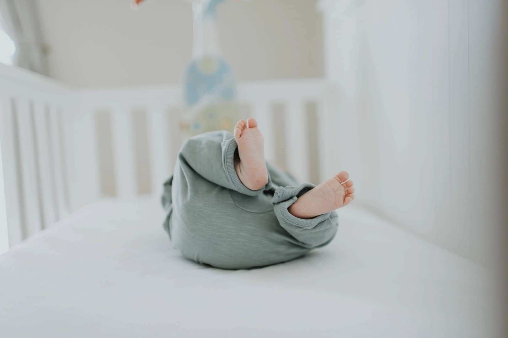 Baby laying in crib on non-toxic mattress