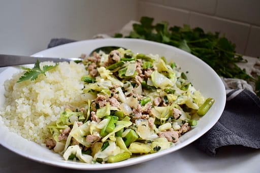 Pork and vegetable stir fry in stainless skillet.